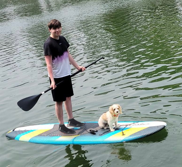 Nick Frederick on a paddle board with a dog