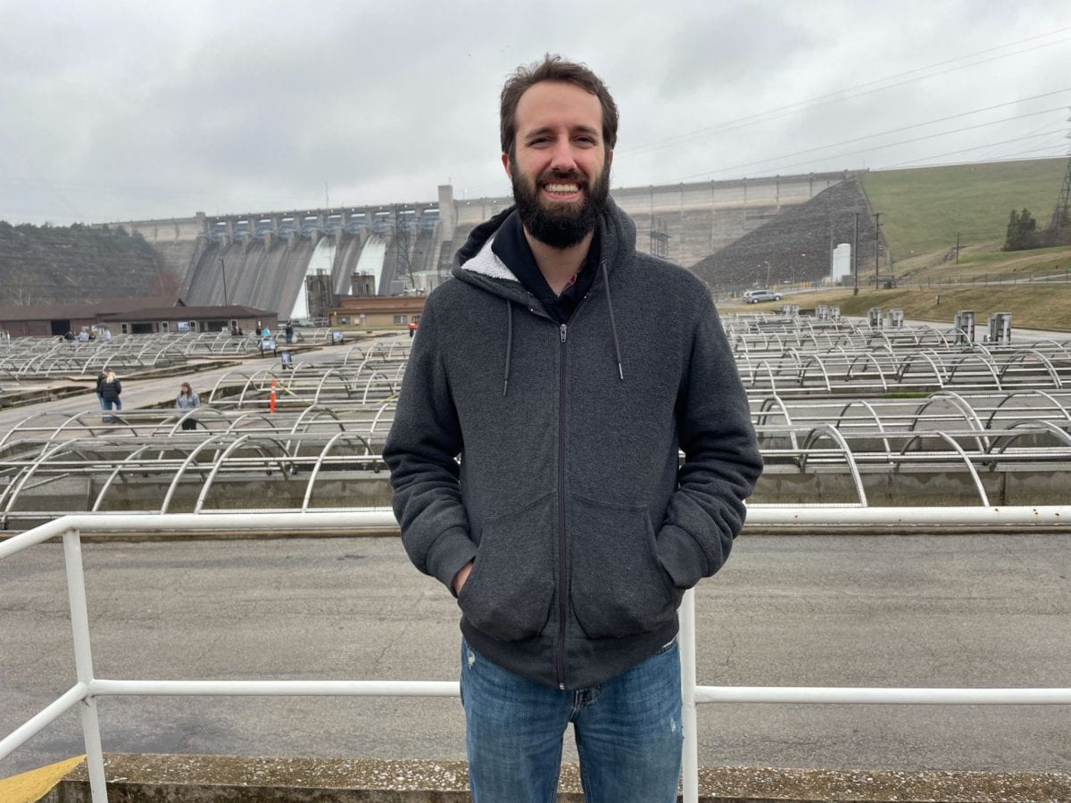 Joey Smith standing in front of a dam.