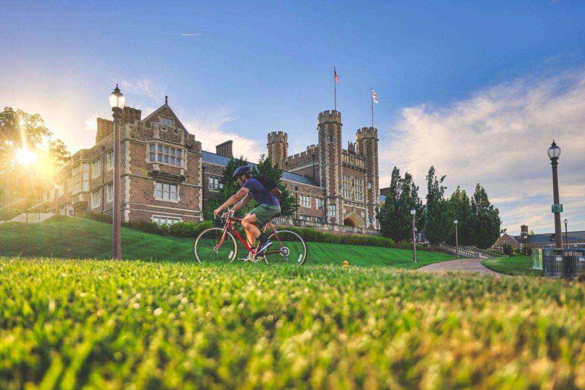 Cyclist rides their bike past Brookings Hall
